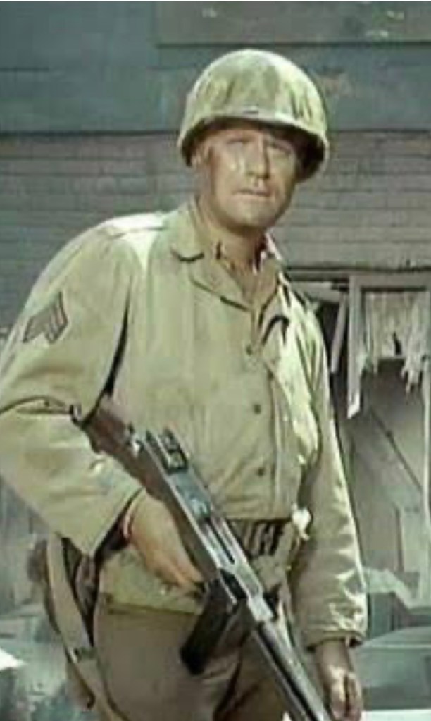 A soldier in a WWII uniform holding a rifle, wearing a helmet, with a backdrop of a damaged building.