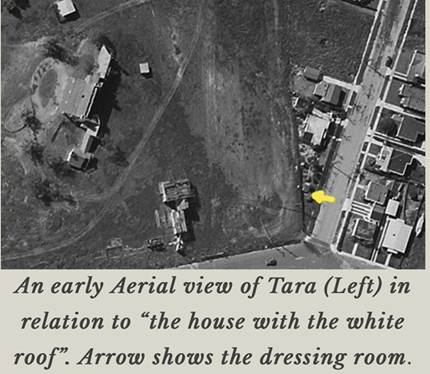 Aerial view of Tara, highlighting its layout in relation to a nearby white-roofed house, with an arrow indicating the location of the dressing room.