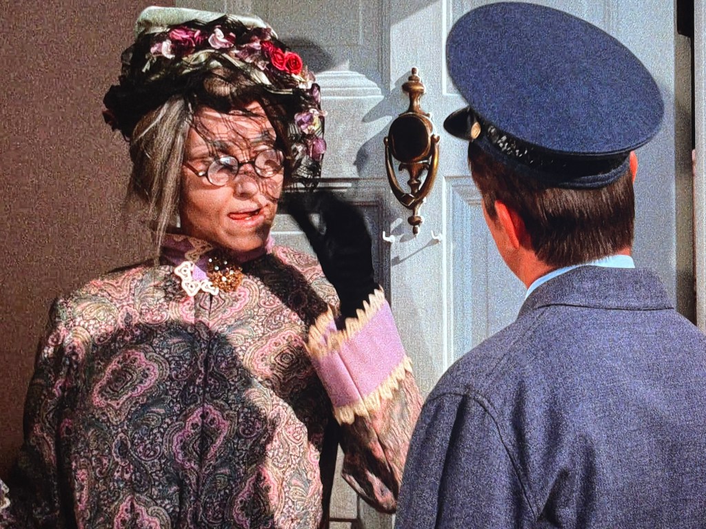 An elderly woman in a floral hat and glasses stands at her front door, engaging with a young postal worker in a blue uniform.