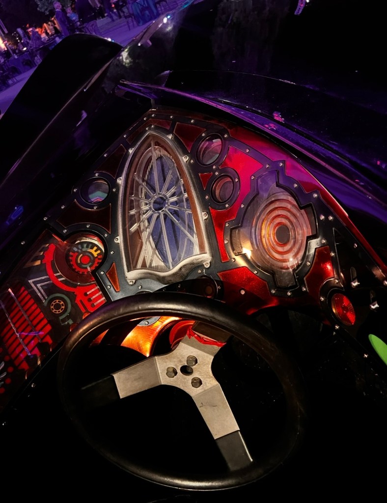 Close-up view of a unique car dashboard featuring colorful, intricate designs and a sleek steering wheel.