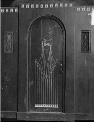 A vintage door featuring a curved top, intricate designs, and two sidelights with decorative glass panels.