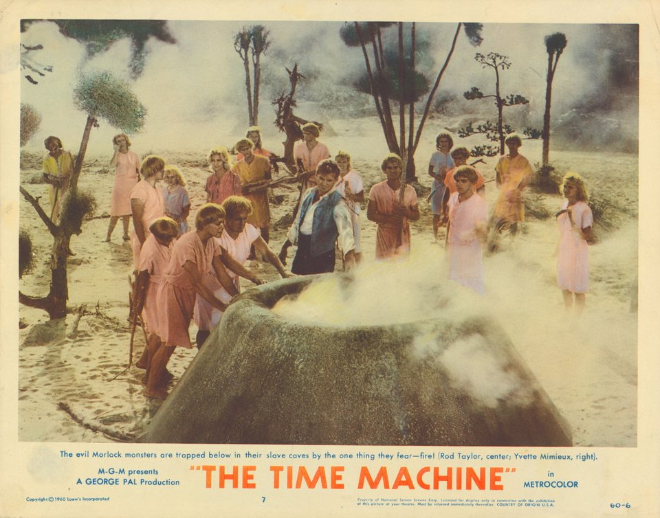 A scene from 'The Time Machine' featuring several characters observing a large, steaming volcano while exhibiting expressions of fear and concern.