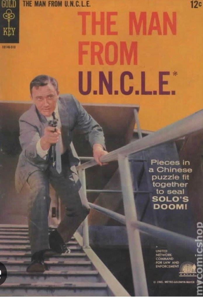 A retro comic book cover featuring a man in a suit holding a gun while ascending stairs, with bold text reading 'THE MAN FROM U.N.C.L.E.' and a tagline about a Chinese puzzle.